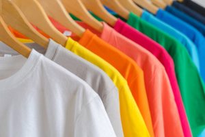 Close up of Colorful t-shirts on hangers, apparel background